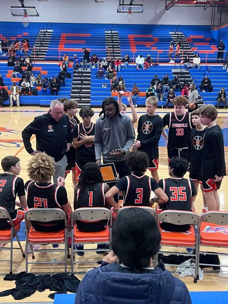 Armon Fletcher coaching a high school team huddle